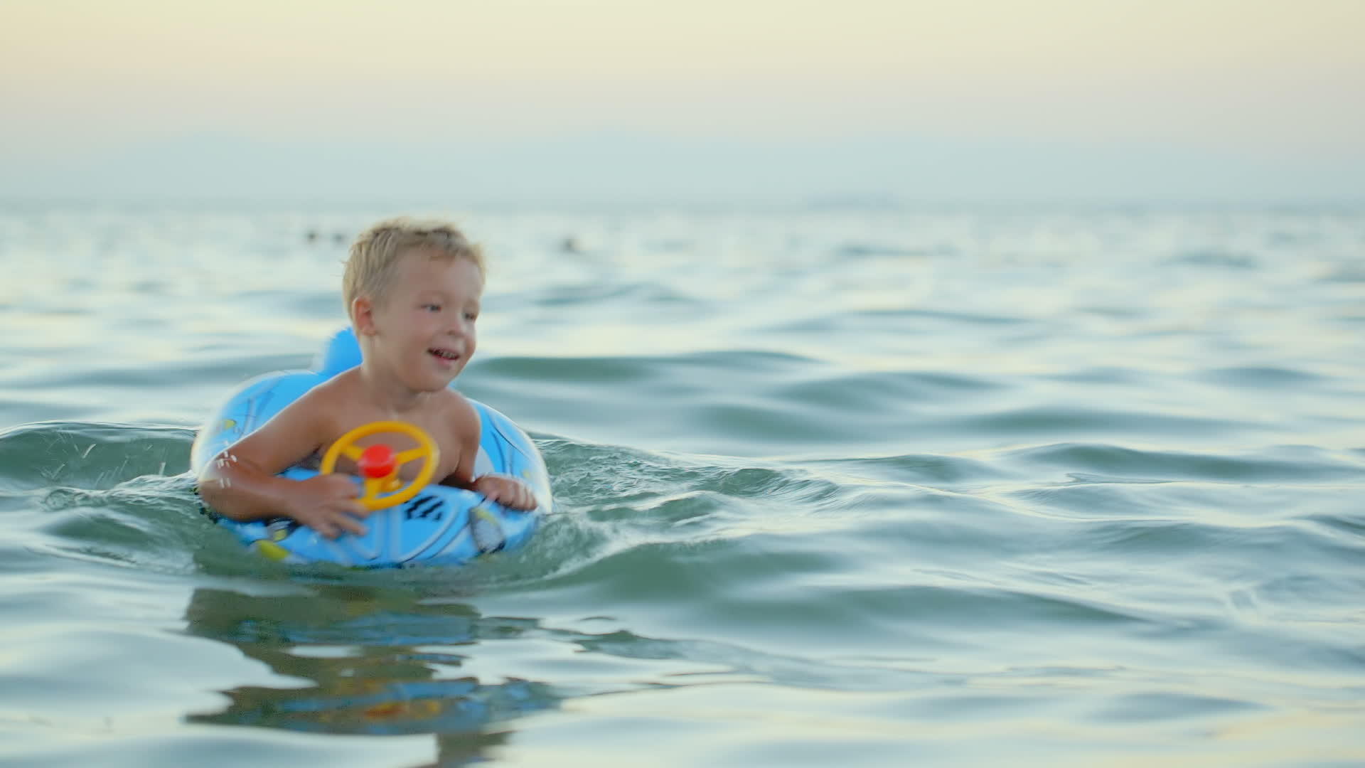 男孩在海里用橡胶环游泳视频的预览图