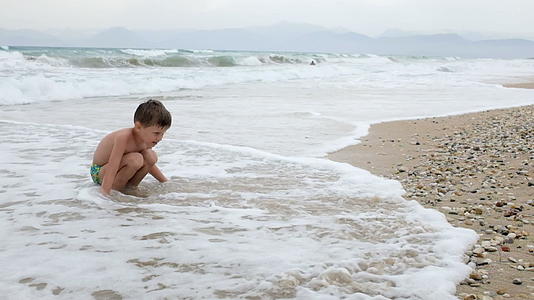 小男孩在沙滩上玩耍视频的预览图