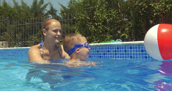 母亲和儿子在游泳池里学习游泳视频的预览图