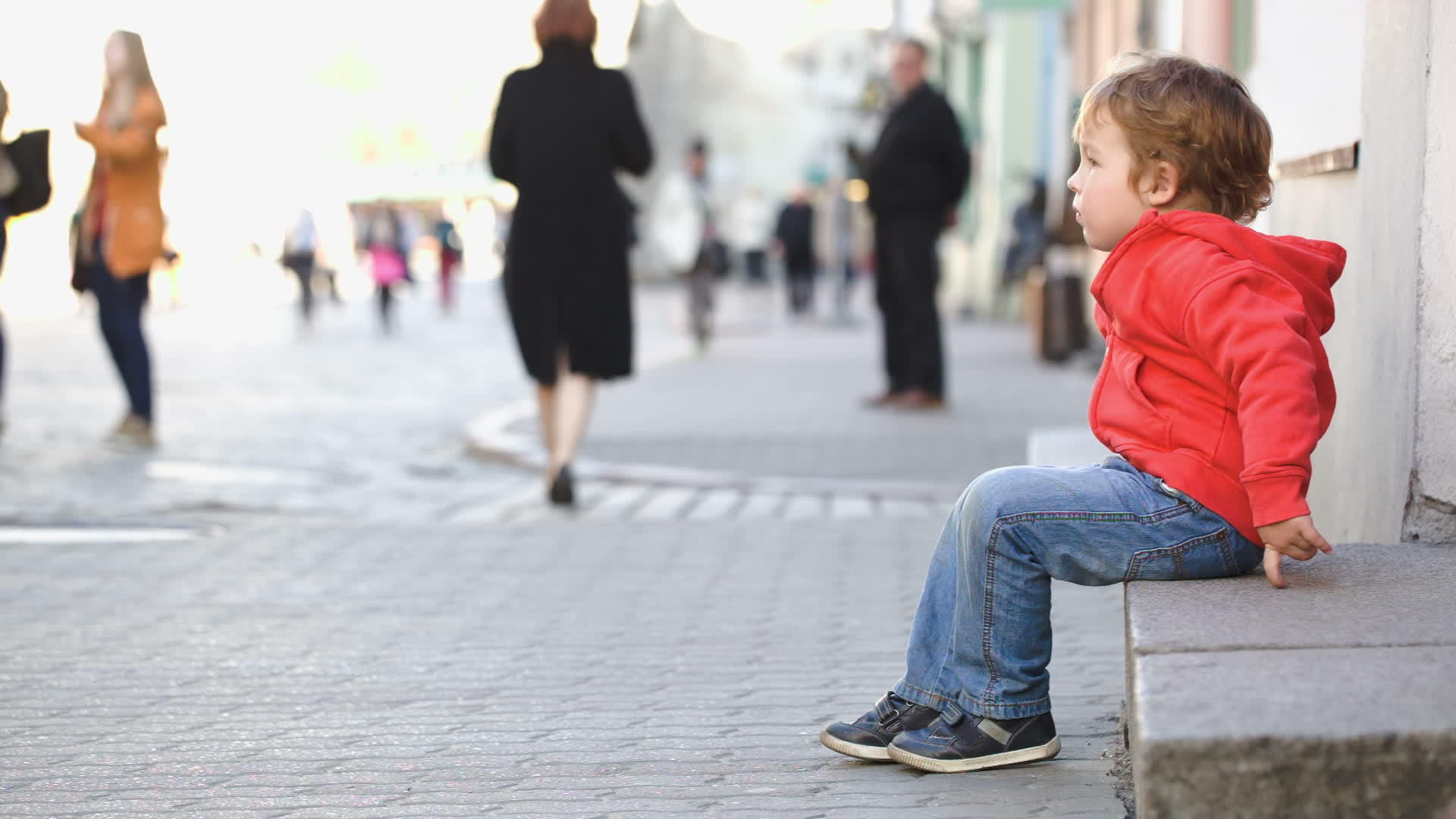 独自坐在街上的小男孩经过马路视频的预览图