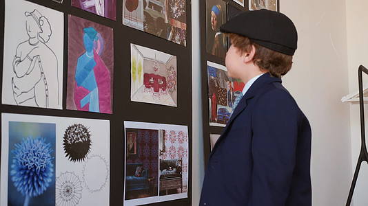 小男孩在美术馆里看画小男孩在创意画廊里寻找艺术画视频的预览图