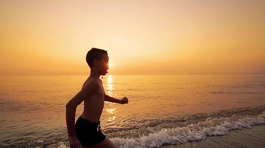 孩子们带着充满活力的海洋日落在沙滩上奔跑视频的预览图