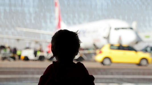 小男孩看着机场的飞机视频的预览图