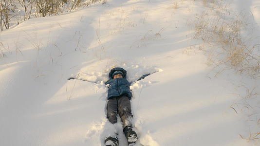 孩子让雪天使躺在雪地上视频的预览图