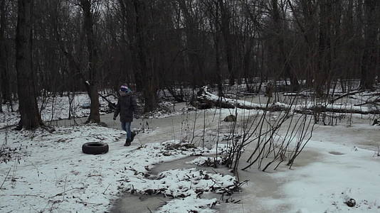 青少年从冬季公园的路上拿走废旧轮胎视频的预览图