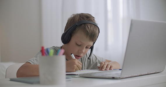 孩子们的男孩们正在用笔记本电脑和手持耳机听音乐视频的预览图