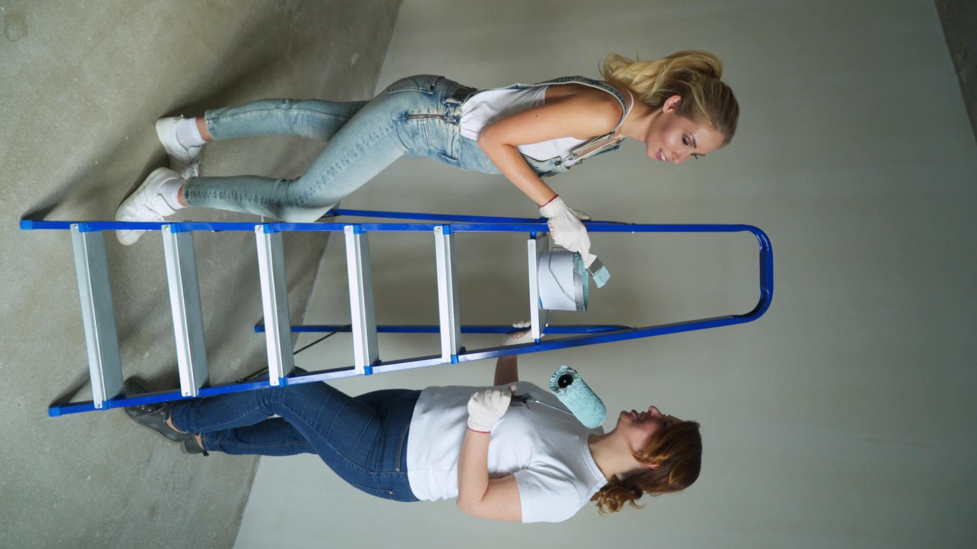两名女工用滚筒机在墙上涂漆视频的预览图