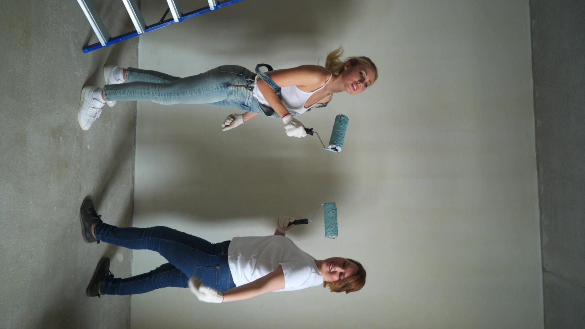 两名女工用滚筒机在墙上涂漆视频的预览图