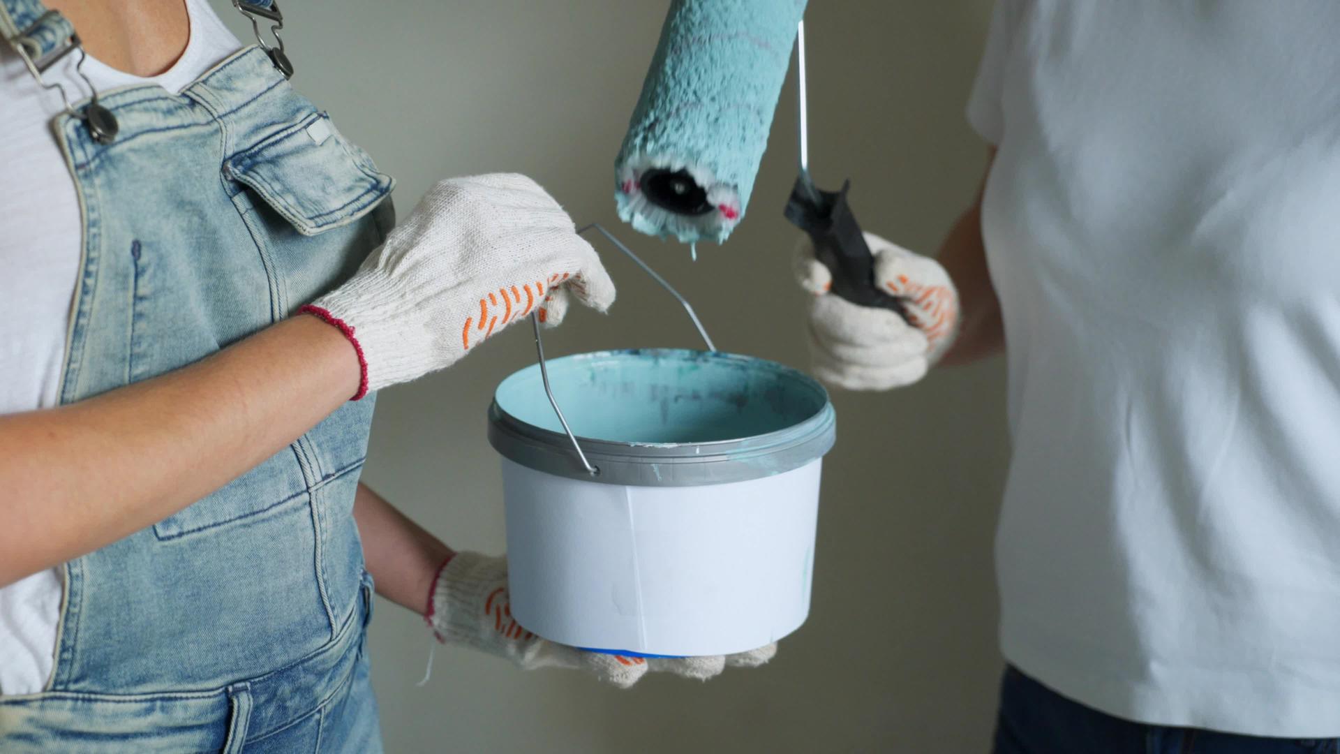 两名女工在公寓或房子里用滚动机油漆墙壁视频的预览图