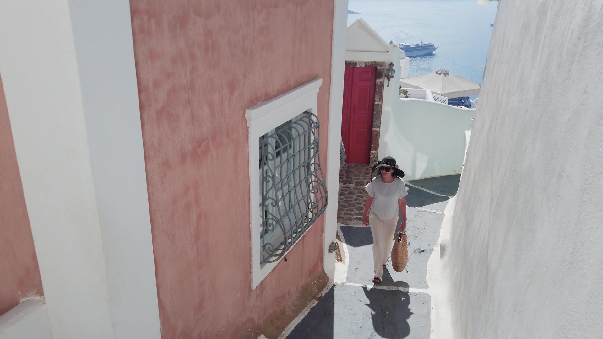 度假的女游客都在Santorini在街上慢慢漫步视频的预览图