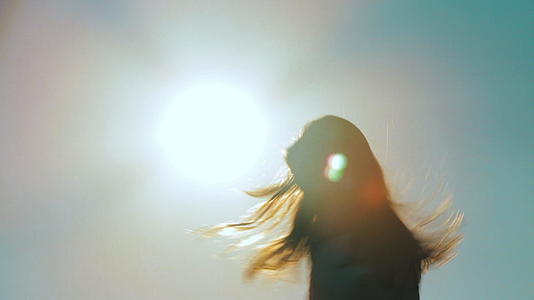 一个无忧无虑、难以辨认的女孩的背影向太阳跳舞视频的预览图