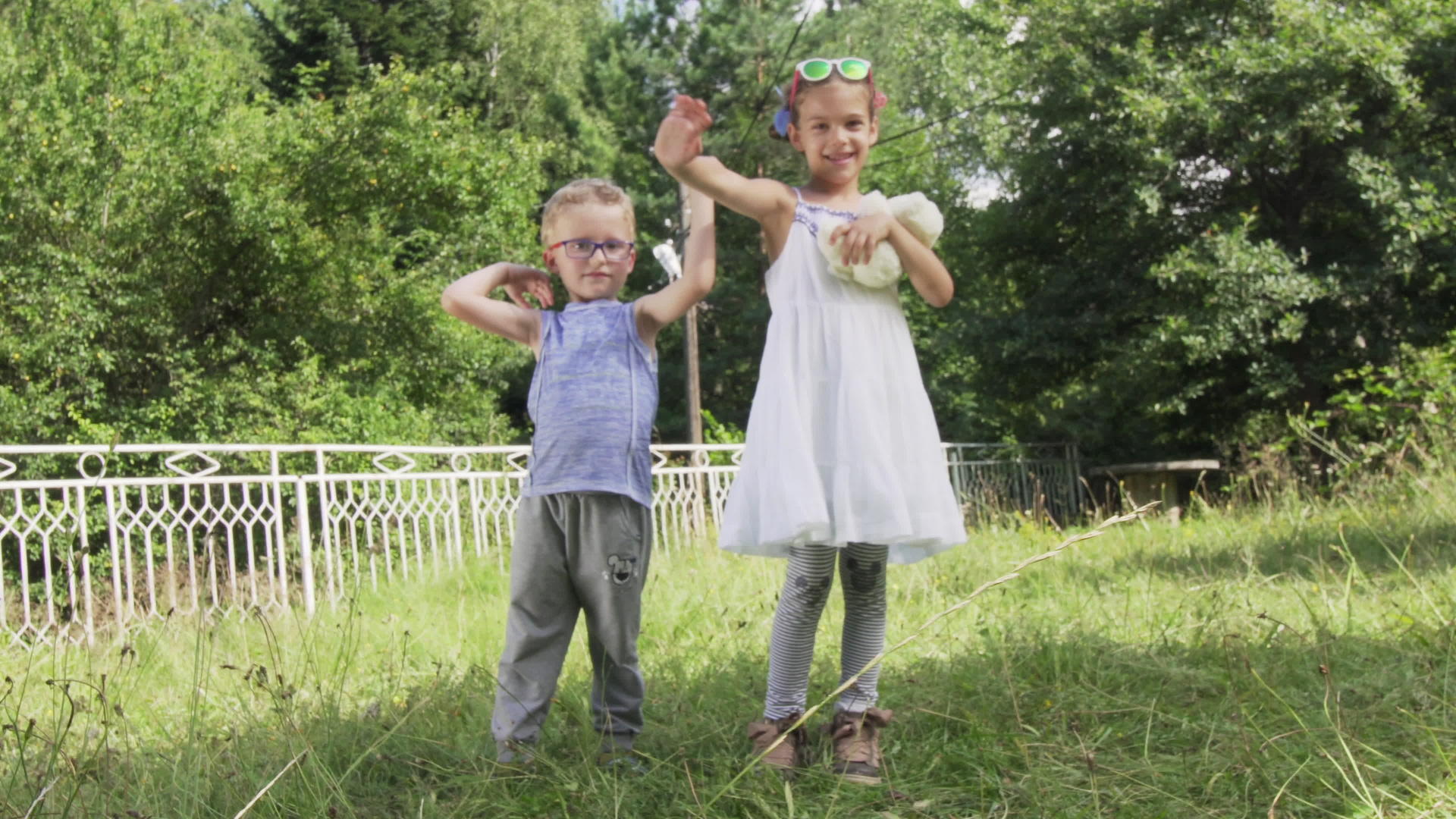 两个孩子挥舞着鬼鬼祟祟的年轻可爱粗心的孩子在后院玩耍视频的预览图