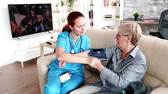 女护士测量老年妇女的血压视频的预览图