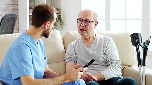 男护士和一个疗养院的病人谈论他的健康视频的预览图