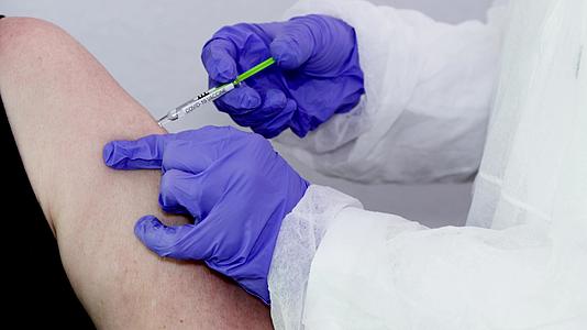 微生物学家或带有蓝色手术手套的医务工作者给予疫苗注射视频的预览图