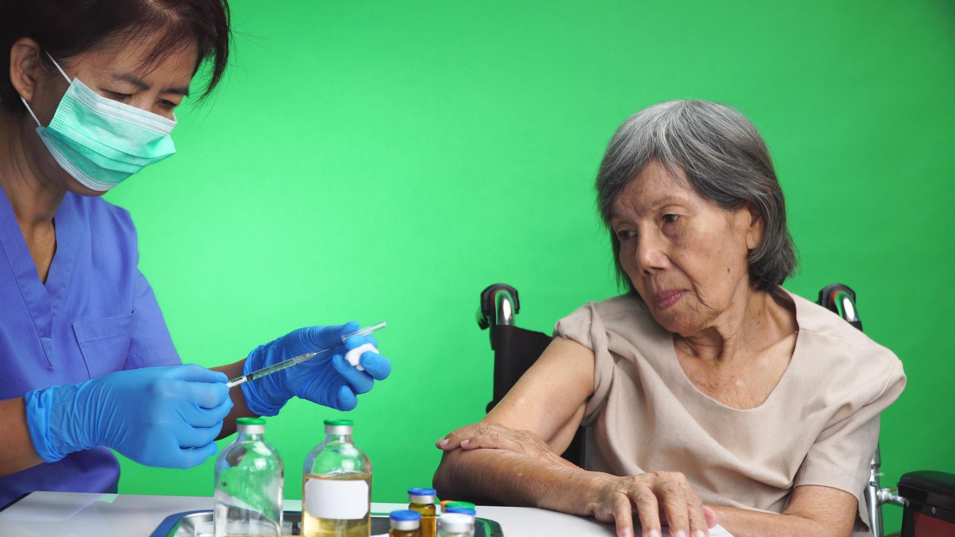 给老年妇女接种疫苗的护士关上门视频的预览图
