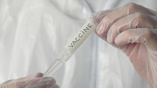 科学实验室的科学家持有带有疫苗铭文的管子医学实验室视频的预览图