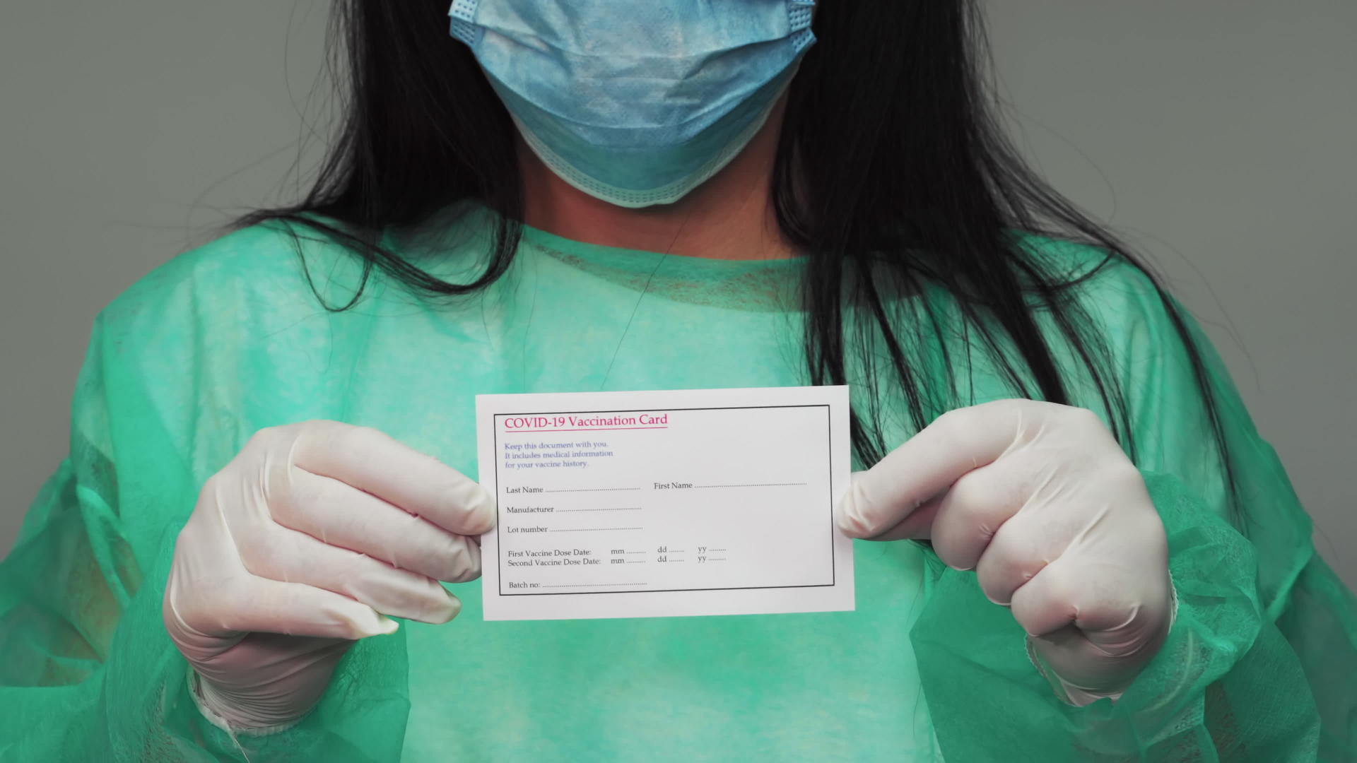 拥有防护绿色西装的化学家持有疫苗卡视频的预览图