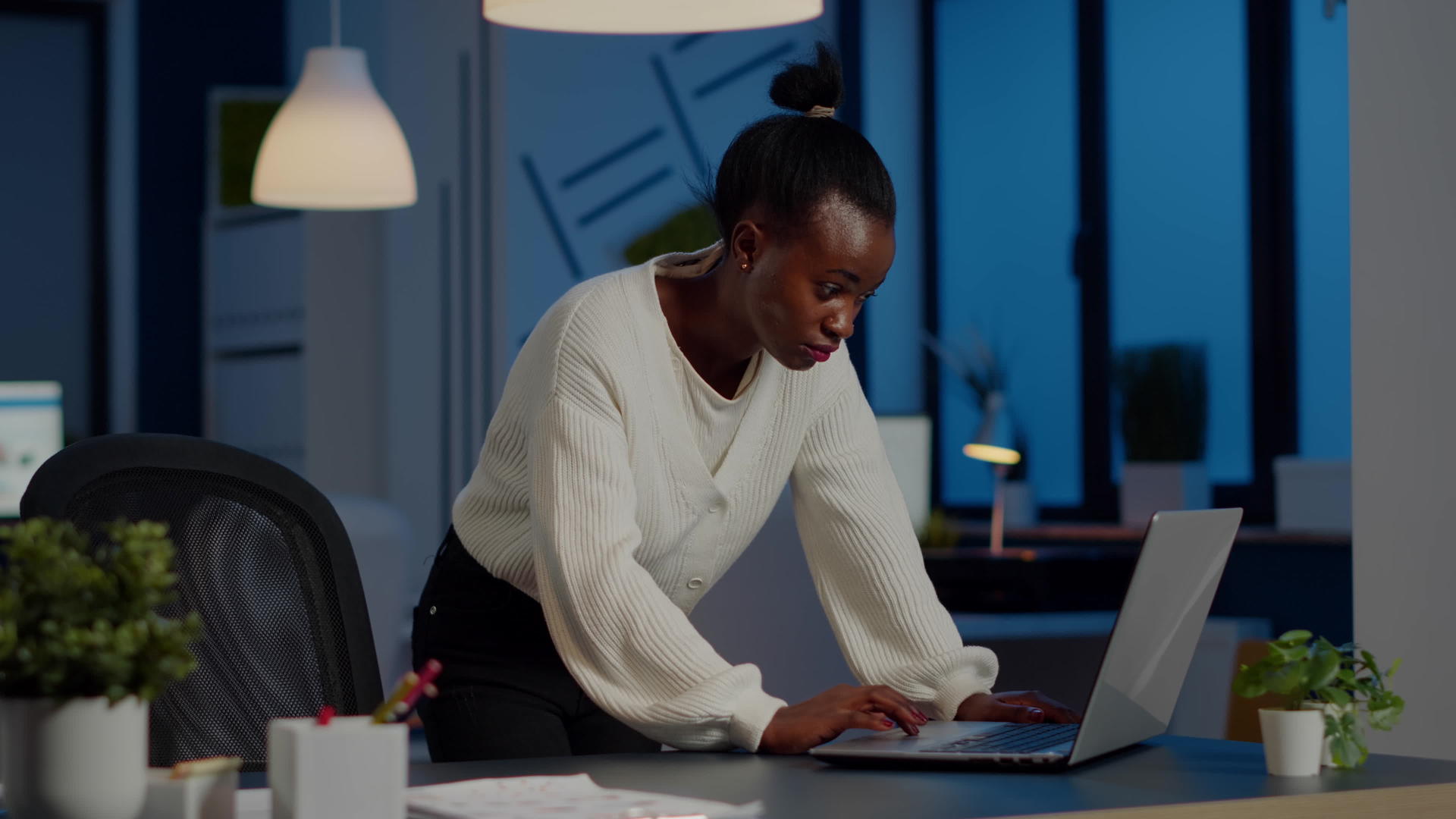 黑人女经理站在桌子上搜索笔记本电脑和相机的桌子视频的预览图