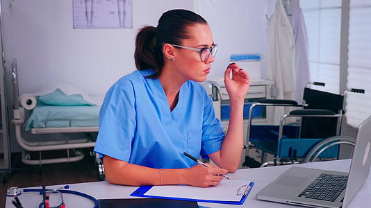 在剪贴板上工作过多的护士在笔记本电脑上工作视频的预览图