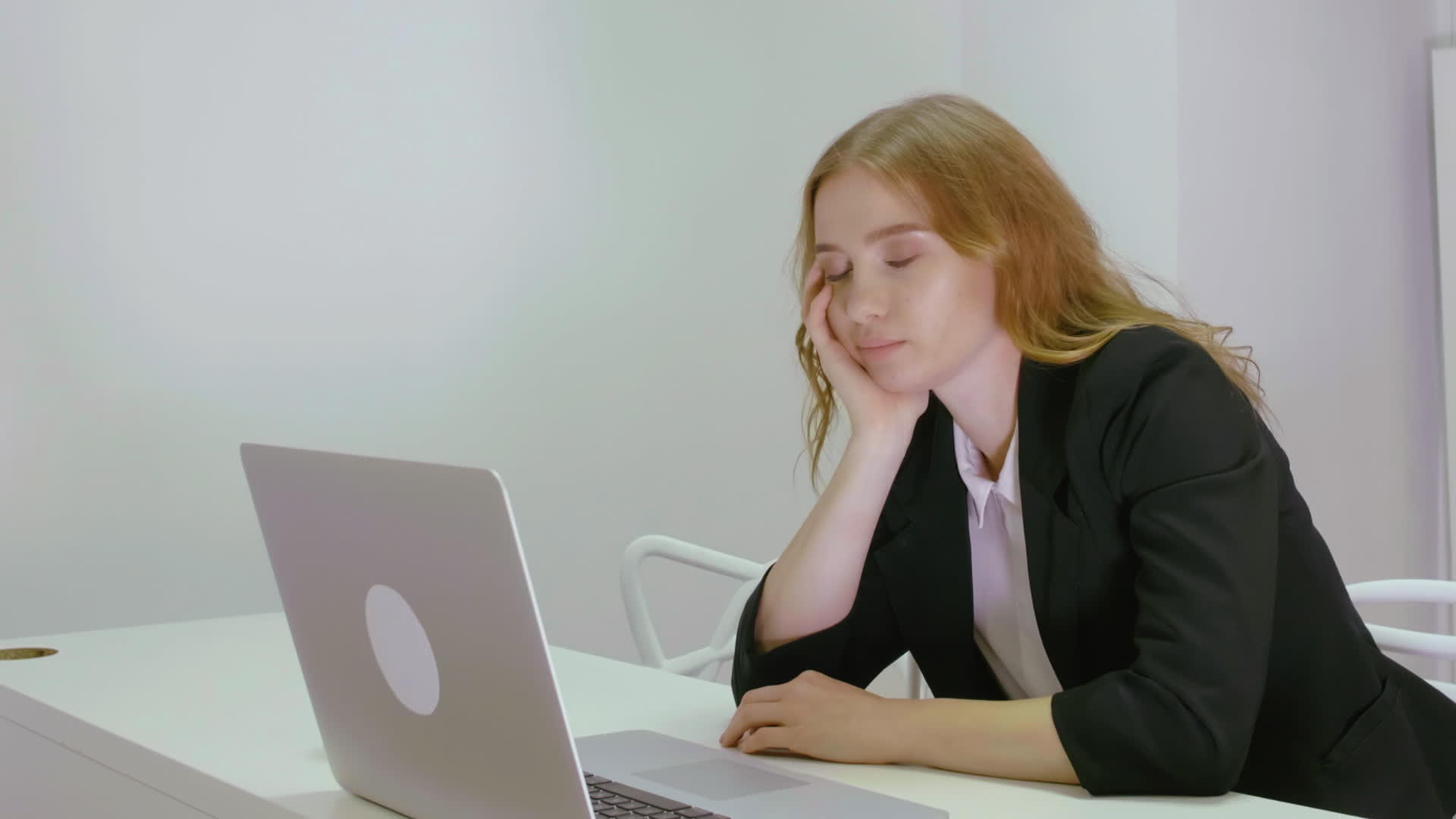睡在工作场所用笔记本电脑的金发女商人视频的预览图