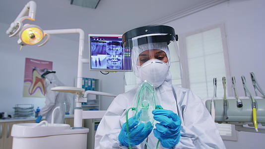 戴着眼罩的牙医在病人身上戴着氧气面罩视频的预览图