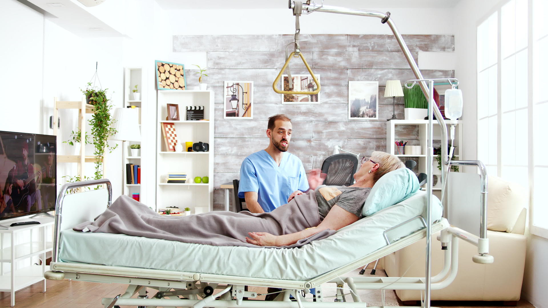 养老院的照顾者和一位躺在医院床上的老妇人交谈视频的预览图