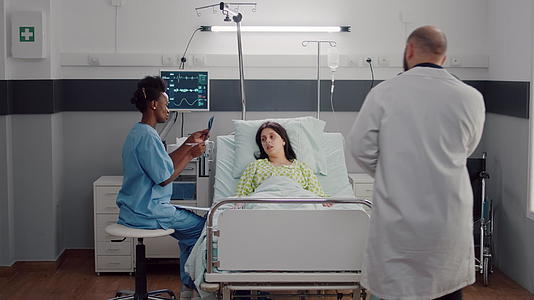 生病的女性病人躺在床上美国护士分析x光骨头视频的预览图