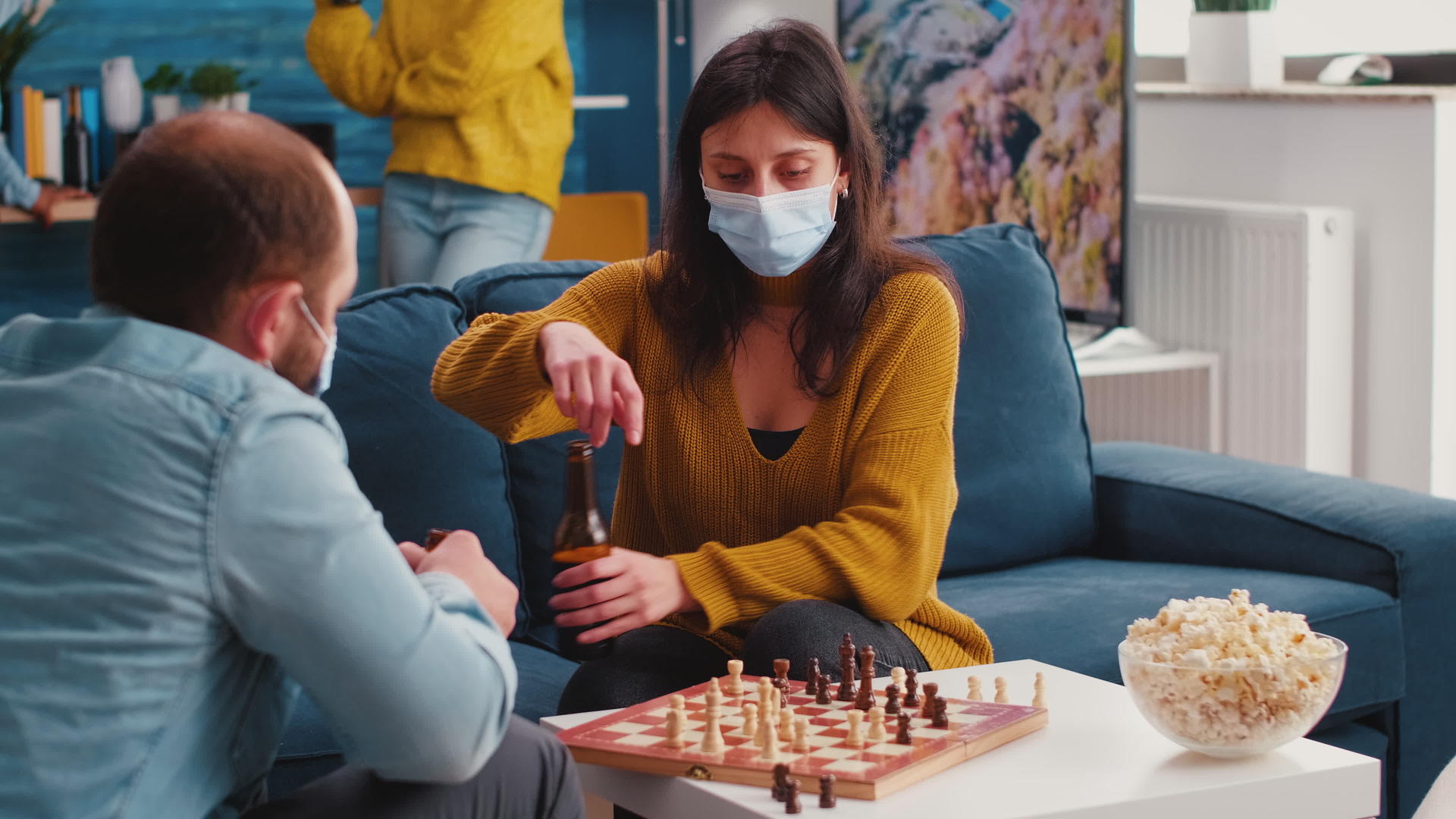 女人戴着面具和男性朋友下棋视频的预览图