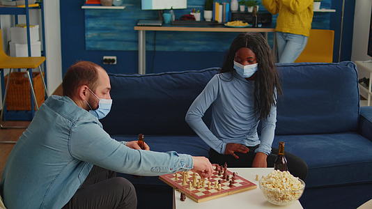 非洲女人戴着面具和男人下棋视频的预览图