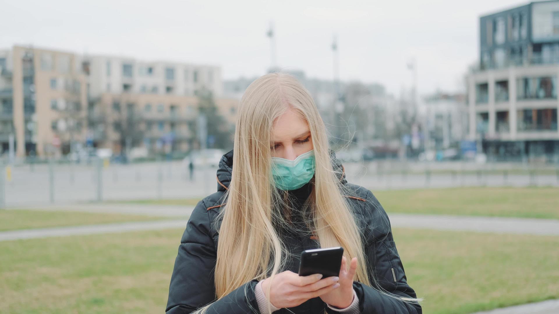 一名身穿医疗面具的中枪女孩阅读了街头疾病的突发新闻视频的预览图