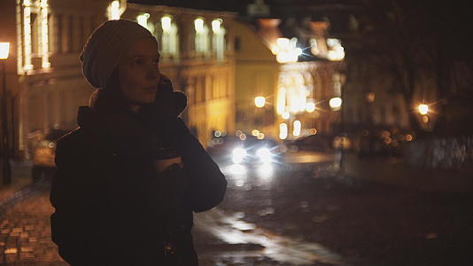 晚上街上的女人喝咖啡在电话里聊天视频的预览图