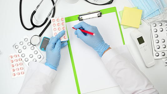 在医生的白色桌子上医生用手拿着一堆药丸在泡罩包装里视频的预览图