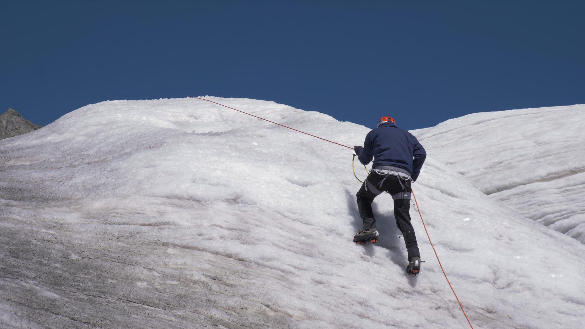 在阳光明媚的白天抽筋的山羊男子用固定绳子爬上山顶视频的预览图