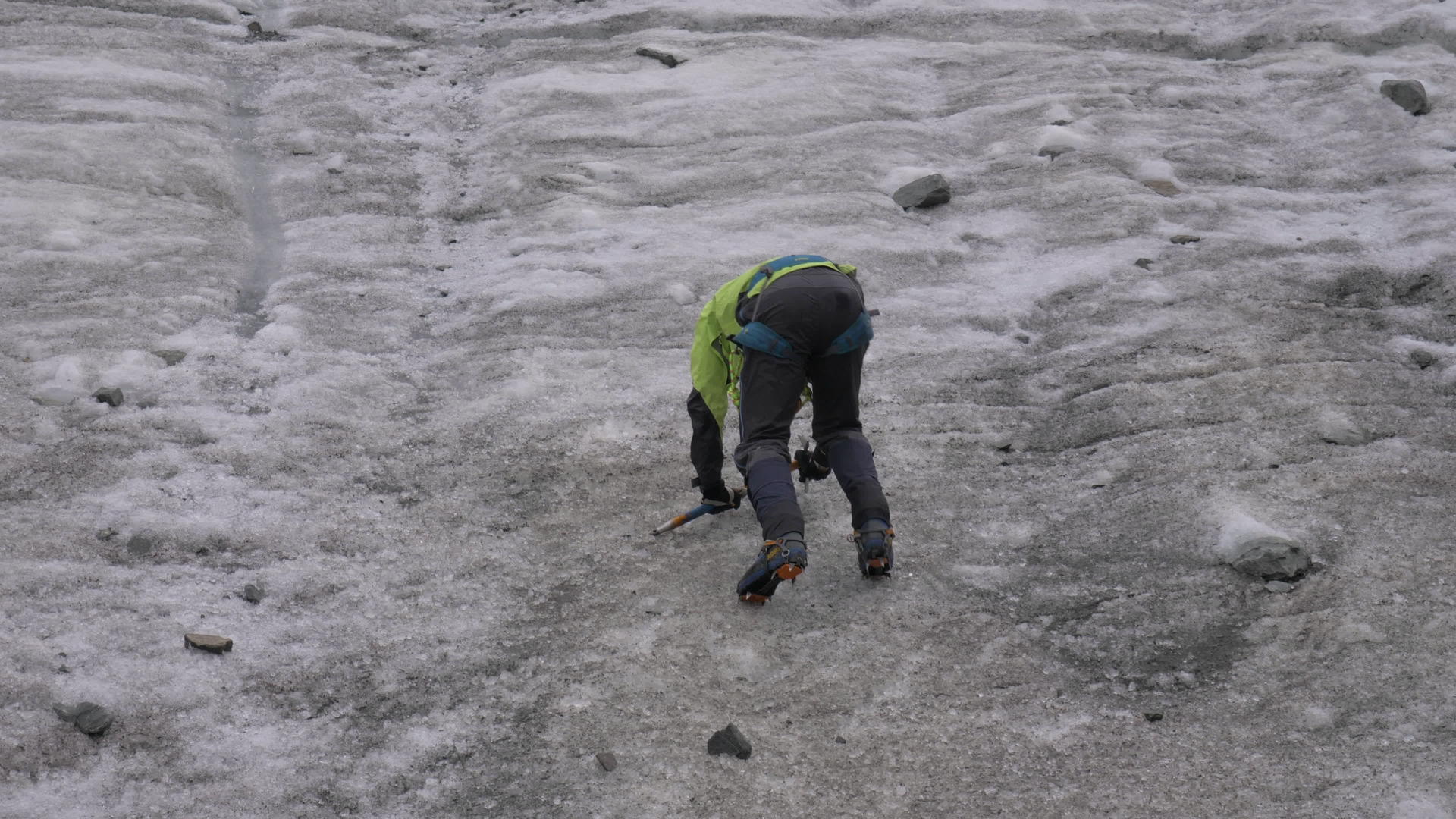 山人用冰斧爬上山顶陡峭的冰坡慢慢移动视频的预览图
