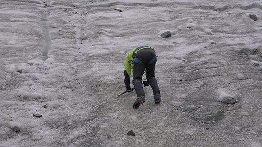 山人用冰斧爬上山顶陡峭的冰坡慢慢移动视频的预览图