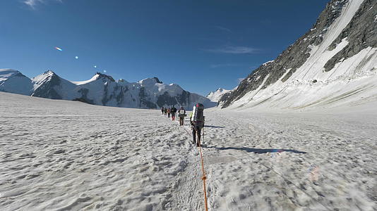 一群带着背包的登山者被绑在雪山的冰川上视频的预览图