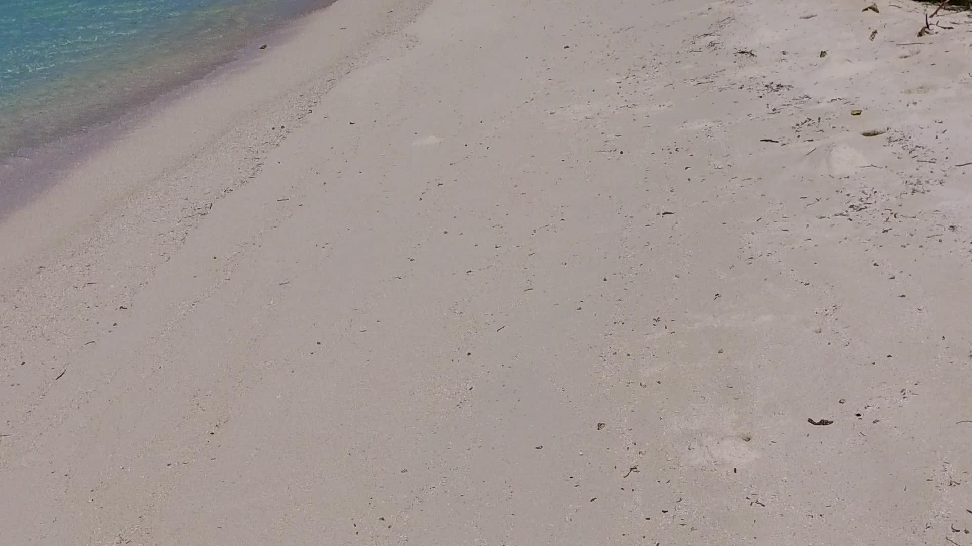 海浪附近的蓝水和白色沙滩背景白沙环礁湖海滩视频的预览图