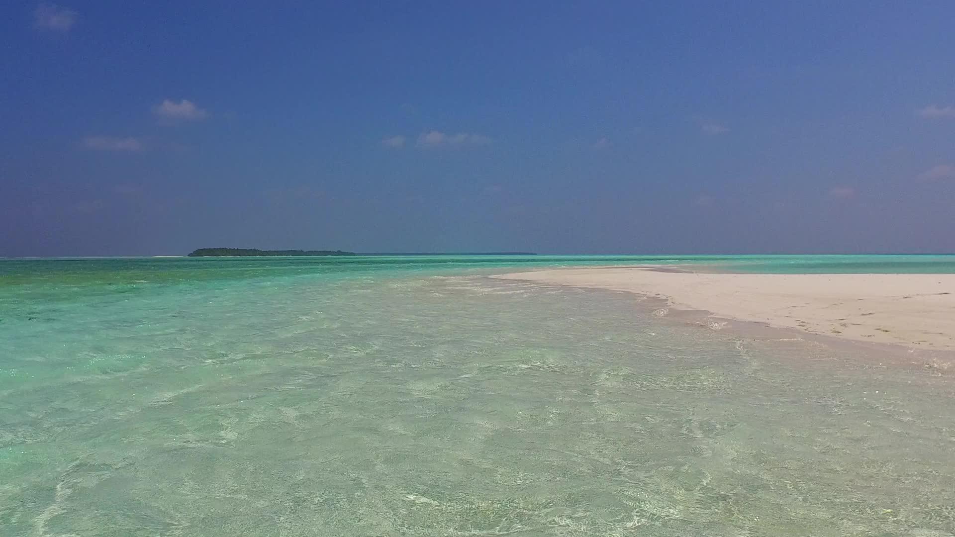 热带海岸线海滩由蓝水和白色海滩在阳光下的浅蓝色背景组成视频的预览图