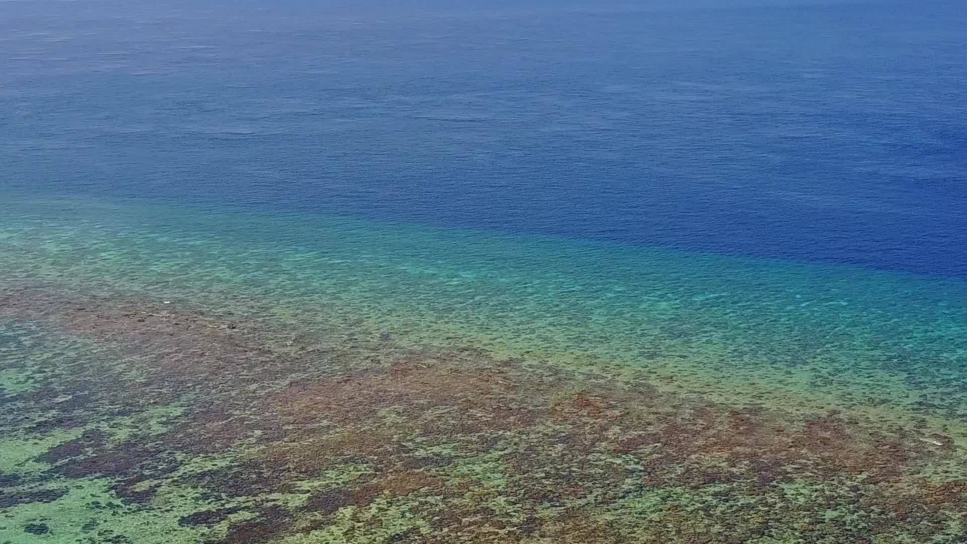 热带湾海滩的背景是蓝色海洋和波浪附近的白色海滩视频的预览图