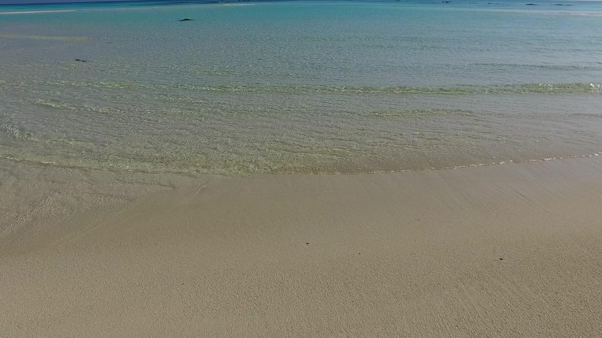 海滩附近的蓝环礁湖和白色沙底的白沙背景打破了海洋泻湖视频的预览图