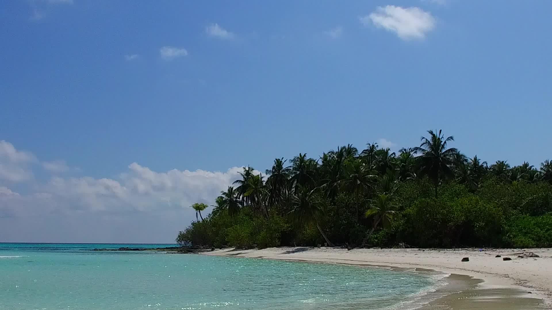蓝色环礁湖和海浪附近清洁的海滩背景阳光明媚的海洋视频的预览图