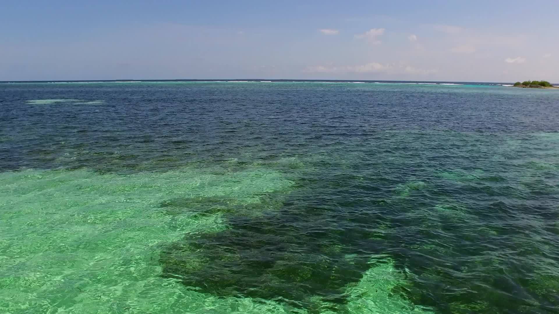 蓝色环礁湖在阳光下有白色沙子背景的白色沙子背景视频的预览图