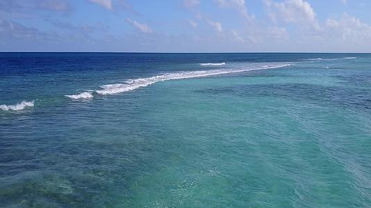 阳光明媚的海滨潮流在海面附近有一个清澈的海洋白色的海滩背景视频的预览图