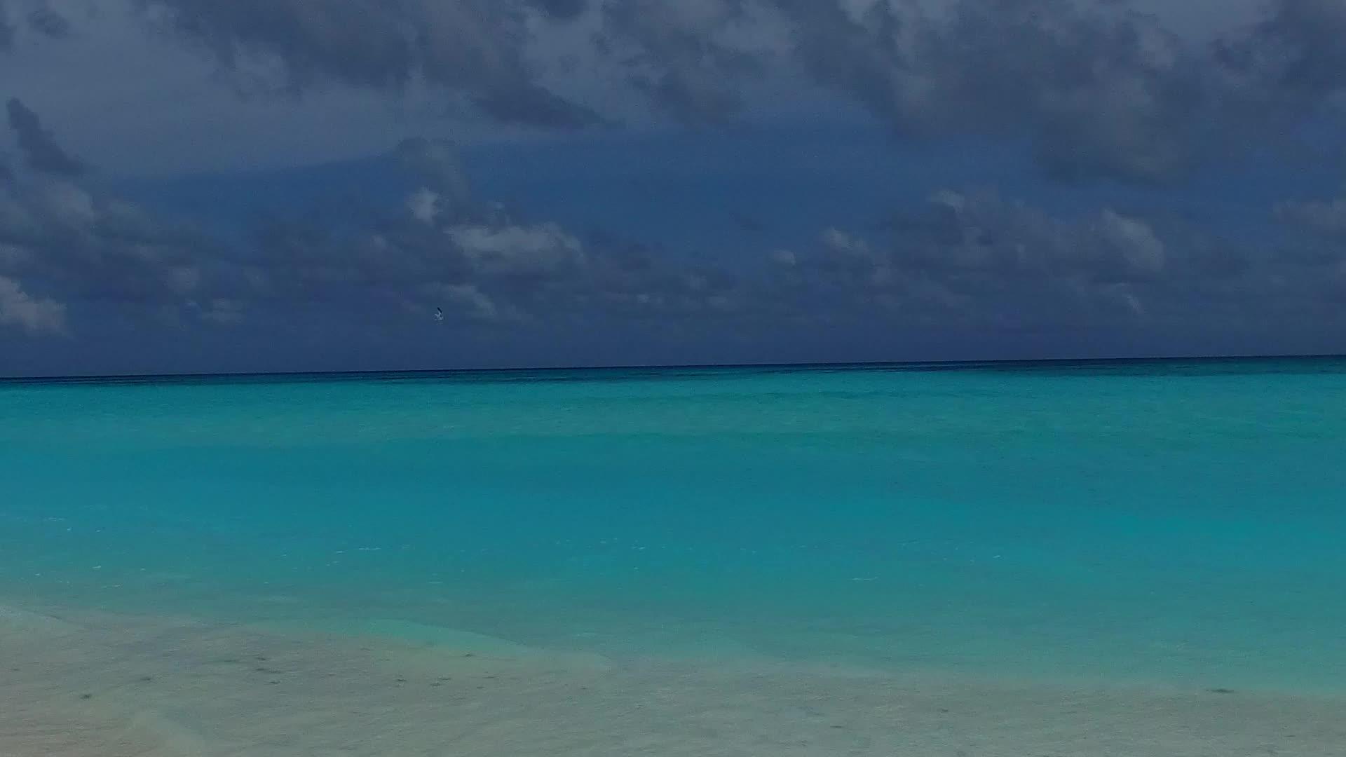阳光明媚的旅游业通过海浪附近的绿色海滩有白色的海滩背景视频的预览图