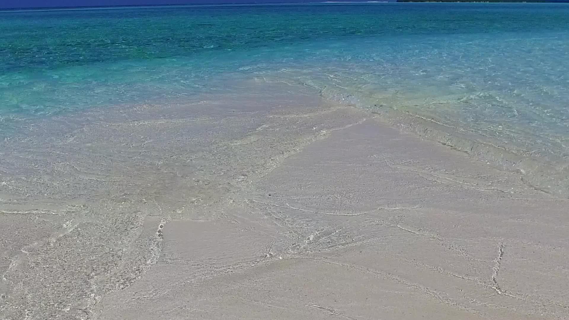 通过透明的海洋和度假胜地附近的白色沙沙背景视频的预览图