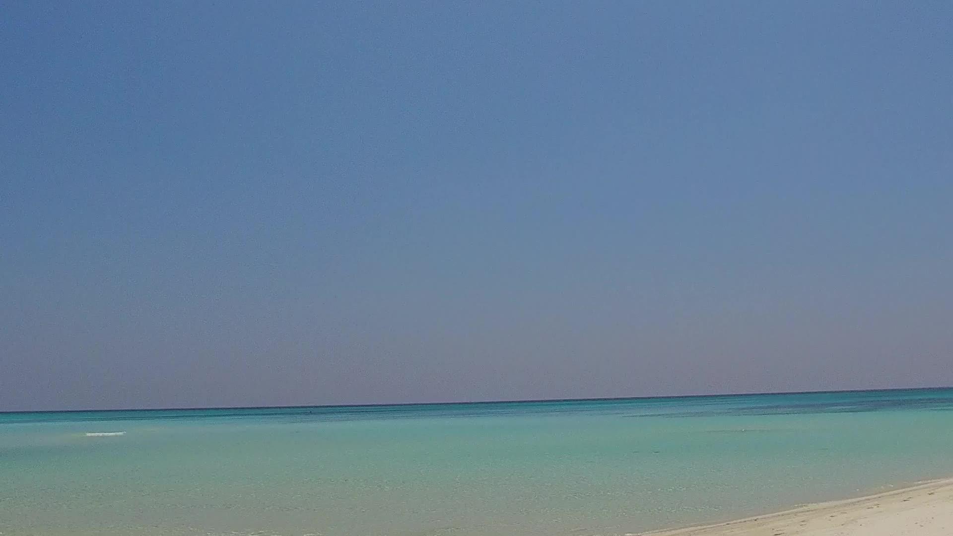 在度假胜地附近的白色海滩上享受浅蓝色的海水视频的预览图
