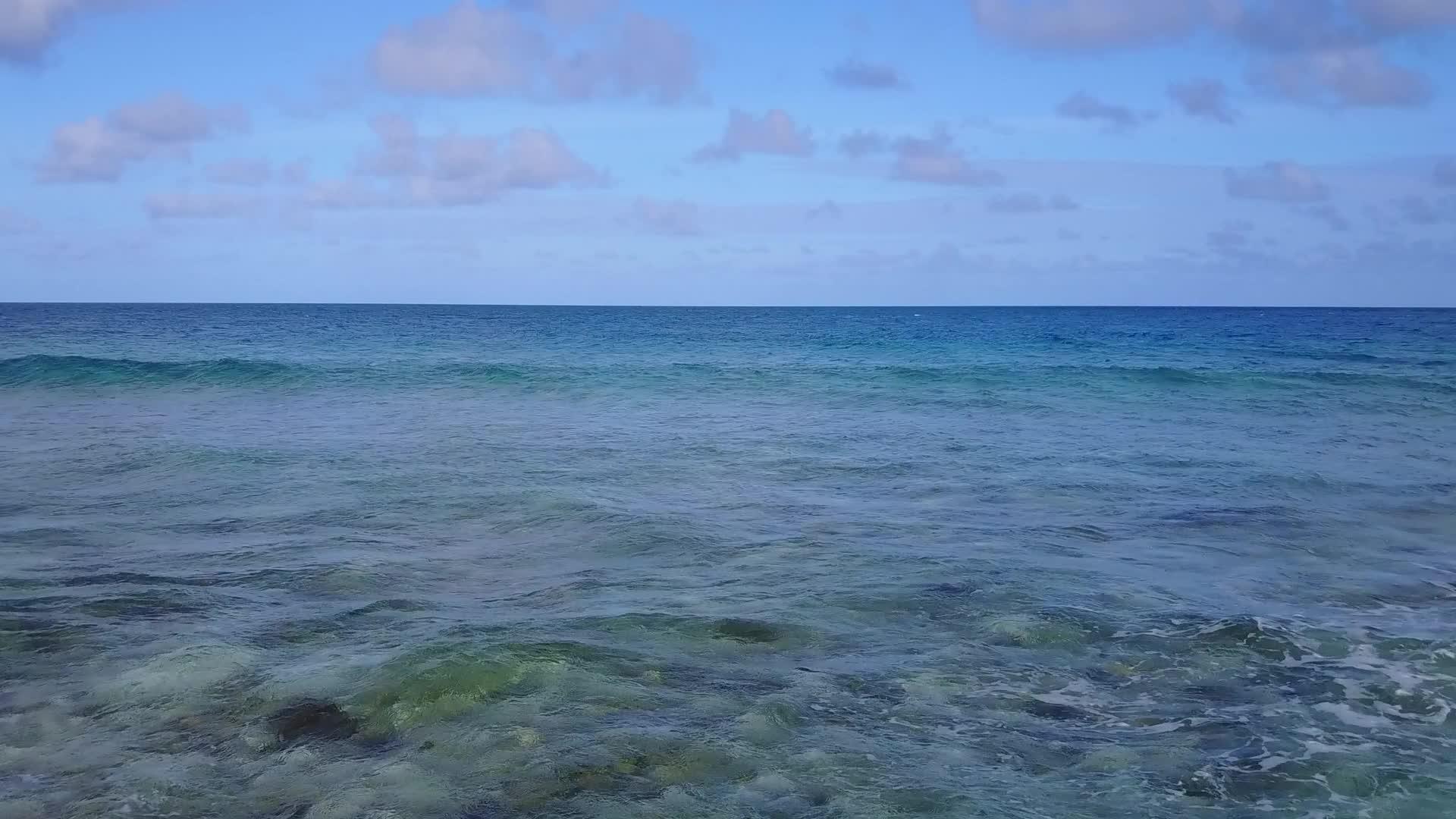 利用海滩附近白色沙滩背景的水蓝色水层打破海滩度假胜地海滩视频的预览图