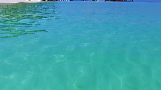阳光明媚的完美岛屿海滩全景海滩附近有水、蓝水和白沙土视频的预览图