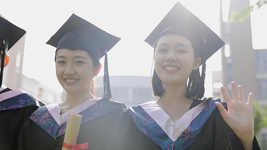 开心微笑的穿着学士服的大学毕业生们视频的预览图